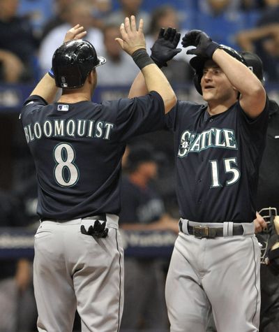 Seattle Mariners' Willie Bloomquist (8) greets Kyle Seager at the plate after Seager's grand slam off Tampa Bay Rays reliever Jake McGee during the eighth inning Tuesday in St. Petersburg, Fla.
 (Associated Press)