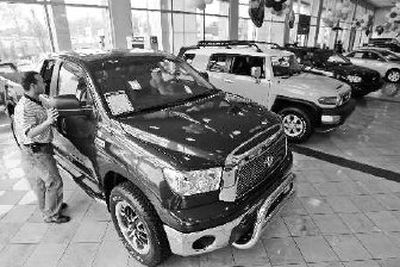 
Louis Barson reads a sticker Tuesday at the Toyota dealership in Ardmore, Pa. 
 (Associated Press / The Spokesman-Review)