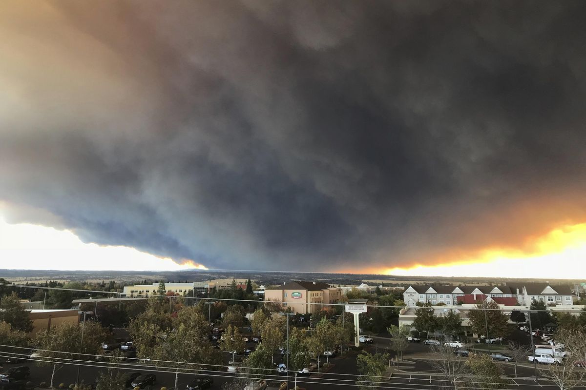 The massive plume from the Camp Fire, burning in the Feather River Canyon near Paradise, Calif., wafts over the Sacramento Valley as seen from Chico, Calif., on Thursday, Nov. 8, 2018. (David Little / Associated Press)