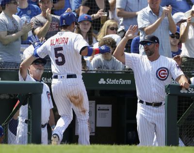 Chicago Cubs manager Joe Maddon, left, and bench coach Brandon Hyde, right, greet Albert Almora Jr. at the dugout after Almora Jr. scored on a single by Anthony Rizzo during the fifth inning of a baseball game against the Detroit Tigers Tuesday, July 3, 2018, in Chicago. (Charles Rex Arbogast / Associated Press)