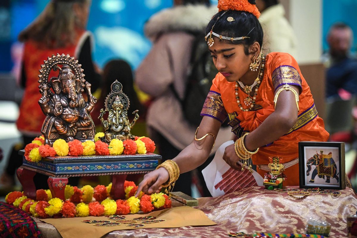 Sindhu Surapaneni, 11, arranges the setting around Ganesha the Indian elephant god during the Celebration of New Year