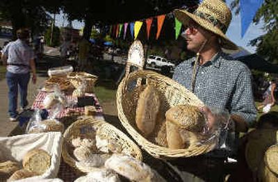 
Scott Coogan talks with customers at his bread stand at the Sandpoint Farmers Market. Coogan and his wife, Joyce, believe God wanted them to move from Connecticut to their remote home near the Canadian border in Idaho to change their lifestyle radically. 
 (Jesse Tinsley / The Spokesman-Review)
