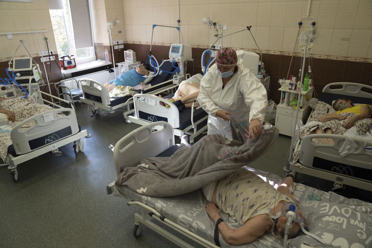In this handout photo released by UNICEF, A nurse covers a patient with coronavirus with a blanket at the ICU at the regional hospital in Kharkiv, Ukraine, Friday, Oct. 15, 2021. Ukraine is suffering through a surge in coronavirus infections, along with other parts of Eastern Europe and Russia. While vaccines are plentiful, there is a widespread reluctance to get them in many countries — though notable exceptions include the Baltic nations, Poland, the Czech Republic, Slovenia and Hungary.  (Evgeniy Maloletka)