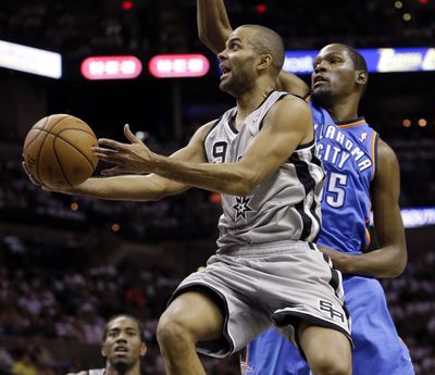 San Antonio’s Tony Parker drives to the basket against Oklahoma City’s Kevin Durant for two of his 14 points on Thursday night. (Associated Press)