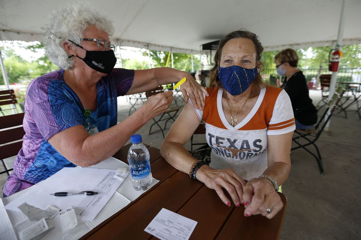 Retired registered nurse Barbara Vicente administers a shot Tuesday of the Pfizer vaccine to Bobbie Guillette, 68, from Austin, Texas, at a clinic at Mother’s Brewing Company in Springfield, Mo. Guillette was visiting family in Springfield a took up Mother’s Brewing on their offer a free beer for getting a vaccine shot.  (Associated Press)