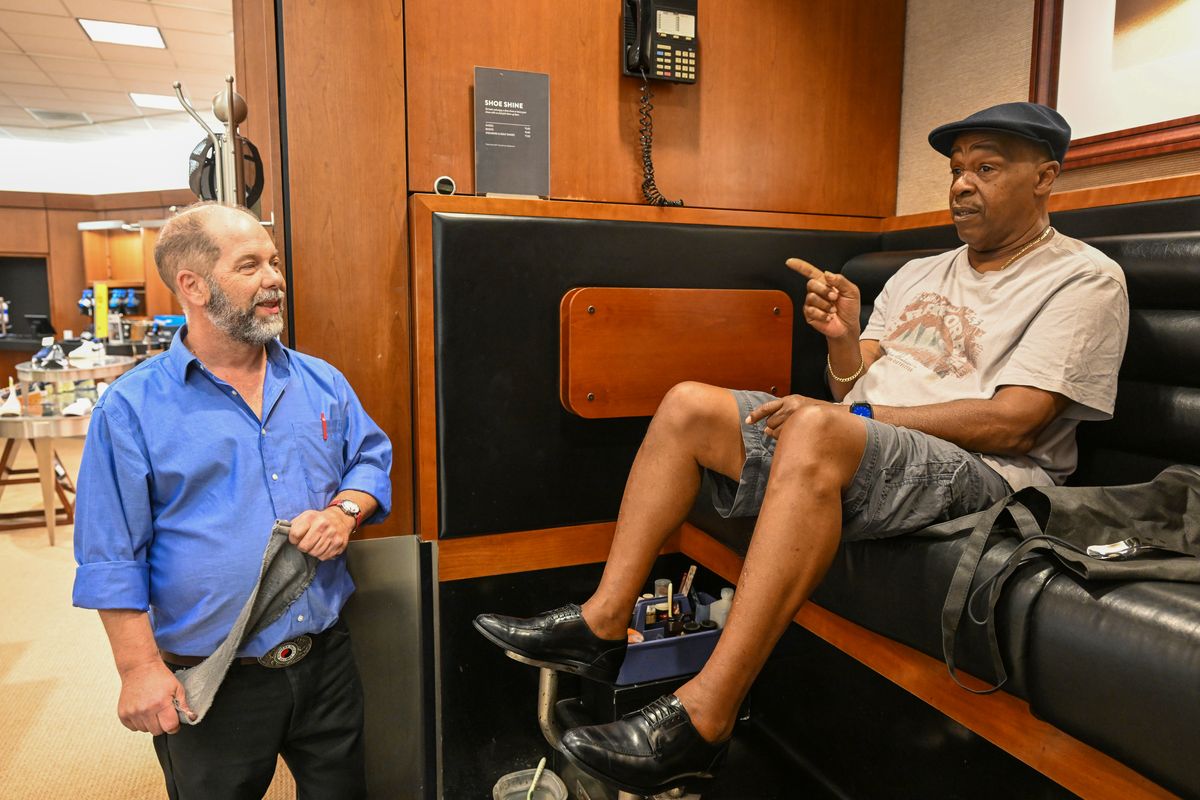 Alex Baker, the veteran shoeshine man at Nordstrom, accepts the compliments of the Rev. Walter Kendricks, a regular customer who is wearing his Sunday shoes, which are regularly treated by Baker, on Thursday in the River Park Square store in downtown Spokane. Kendricks complimented Baker for his extensive knowledge of shoes and shoe care. Baker has been at his station for more than a decade but has shined shoes for more than 30 years at various stands around Spokane and the region.  (Jesse Tinsley/The Spokesman-Review)