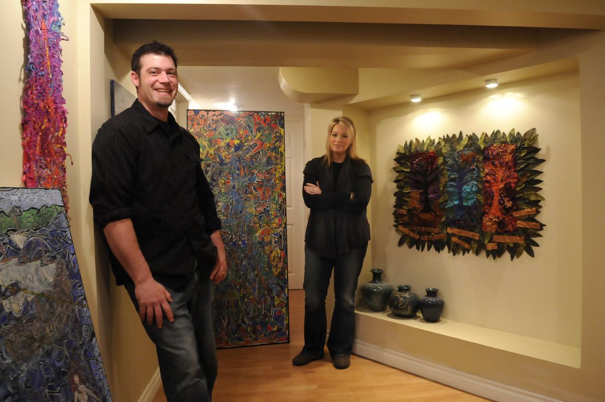 Dirk and Helen Parsons, who are a couple and artists as well, stand in their basement hallway with their work  May 19. Helen is a fiber artist who  uses multiple techniques and textures, and Dirk is a painter who creates intricately detailed canvases that weave abstract and representational imagery together.  (Photos by JESSE TINSLEY / The Spokesman-Review)