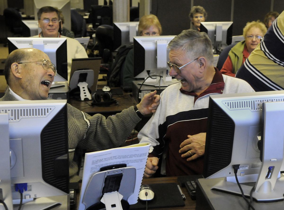 Fred Shiosaki and Burl Hamilton celebrate with each other after completing a simple Word program task while taking the Computer Kindergarten class at the IEL Hillyard Center. “We’re  practically geniuses,” Shiosaki said. (Dan Pelle / The Spokesman-Review)