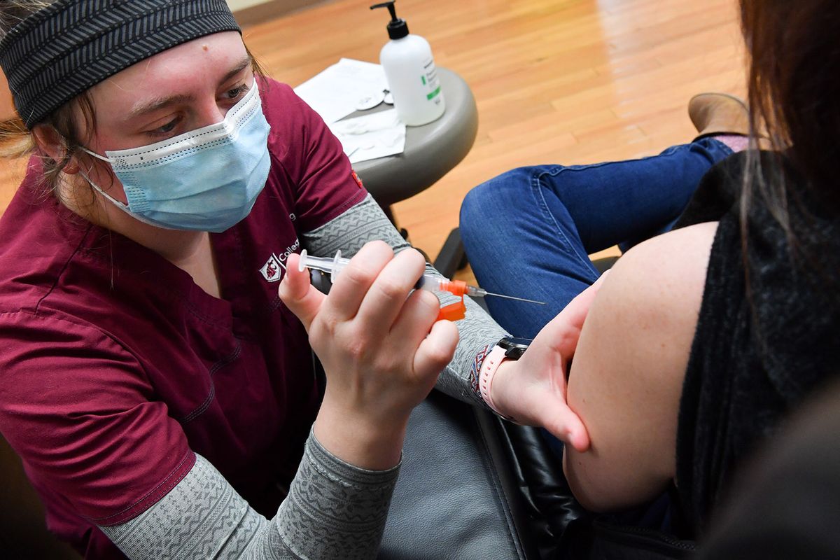 Jennifer Leick, right, receives a Covid-19 vaccine from WSU nursing student Erin McLeod, left, on Friday, January 22, 2021, at Summit Cancer Centers in Spokane, Wash. (Tyler Tjomsland/The Spokesman-Review)