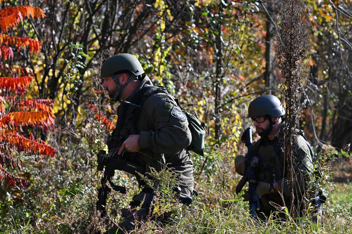 Law enforcement personnel approach a home in Monmouth, Maine, on Oct. 27, 2023, in the aftermath of a mass shooting in Lewiston, Maine. Thousands of anxious small-town Maine residents began a second day under lockdown as police waging a sprawling manhunt struggled to find a U.S. Army reservist accused of killing 18 people in America