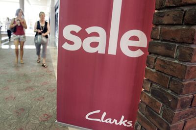Shoppers walk next to sale sign at a mall in San Jose, Calif. Americans scaled back their spending in September, resulting in weak sales for many retailers, as already skittish consumers grappled with the financial meltdown. (Associated Press / The Spokesman-Review)