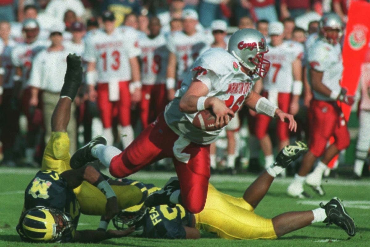 Michigan defenders Dhani Jones and Juaquin Feazell trip up Washington State quarterback Ryan Leaf in the first quarter of the Rose Bowl NCAA football game on Thursday, Jan. 1, 1998 in Pasadena, Calif. (Craig Buck / The Spokesman-Review)
