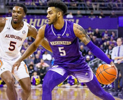 Washington guard Jamal Bey dribbles against Auburn defender Chris Moore during Wednesday’s game in Seattle.  (Courtesy of UW Athletics)