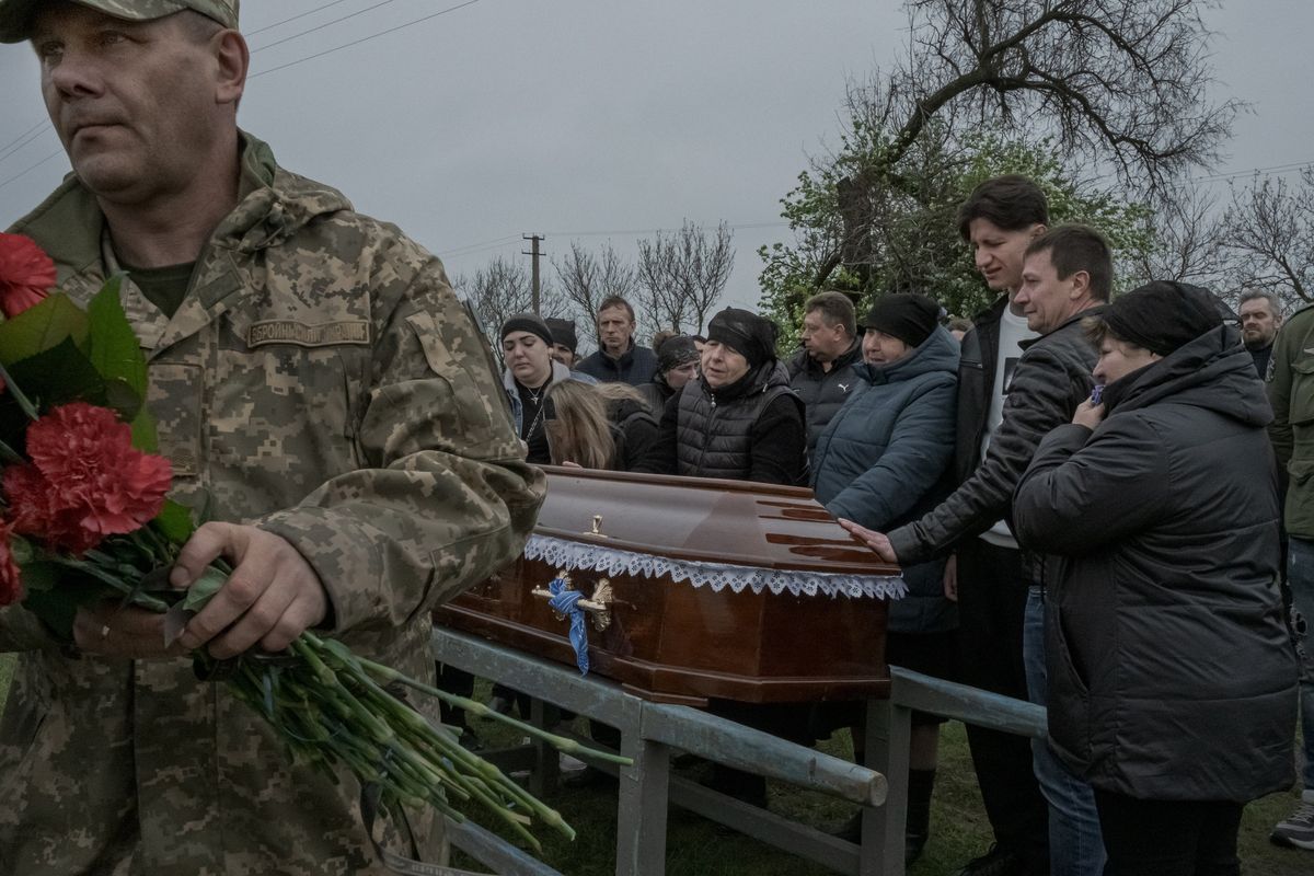 Mourners around the coffin of the Ukrainian soldier Oleksandr Shavalin, who was killed fighting in Bakhmut, at his funeral in Cherkaske, Ukraine, on Saturday, April 29, 2023.    (Mauricio Lima/The New York Times)