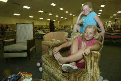 
Port Charlotte, Fla., resident Gabrielle Boyd, 7, sits behind her sister Mikiah, 6, as they watch a movie on television Sunday while staying at a church shelter for victims of Hurricane Charley. 
 (Associated Press / The Spokesman-Review)