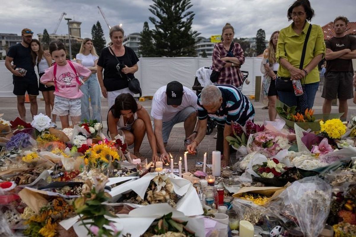 People light candles among the floral tributes for victims and survivors of a deadly mass shooting during a Jewish Hanukkah celebration at Bondi Beach on Dec. 14, in Sydney, Australia.  (Eloisa Lopez/Reuters)