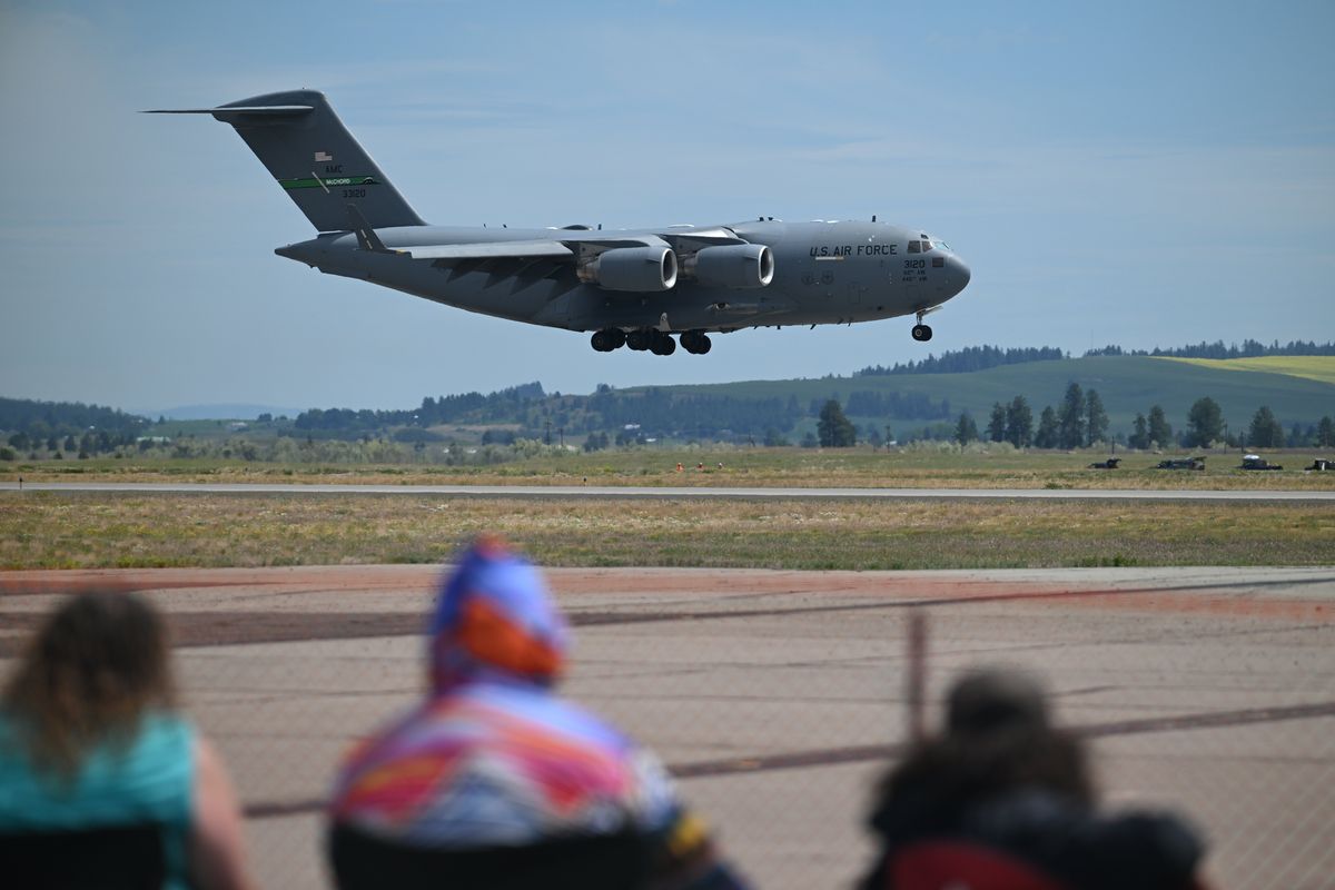 Audience members watch a C-17 Globemaster make a slow pass down the runway at the Skyfest airshow at Fairchild Air Force Base Saturday, June 22, 2024.  (Jesse Tinsley/THE SPOKESMAN-REVIEW)