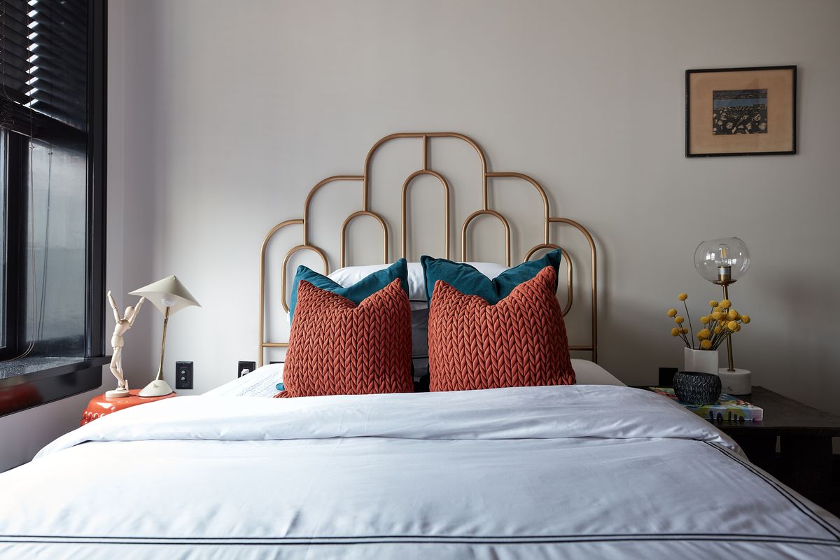 A scalloped iron headboard adds a feminine touch in this bedroom.  (Scott Gabriel Morris)