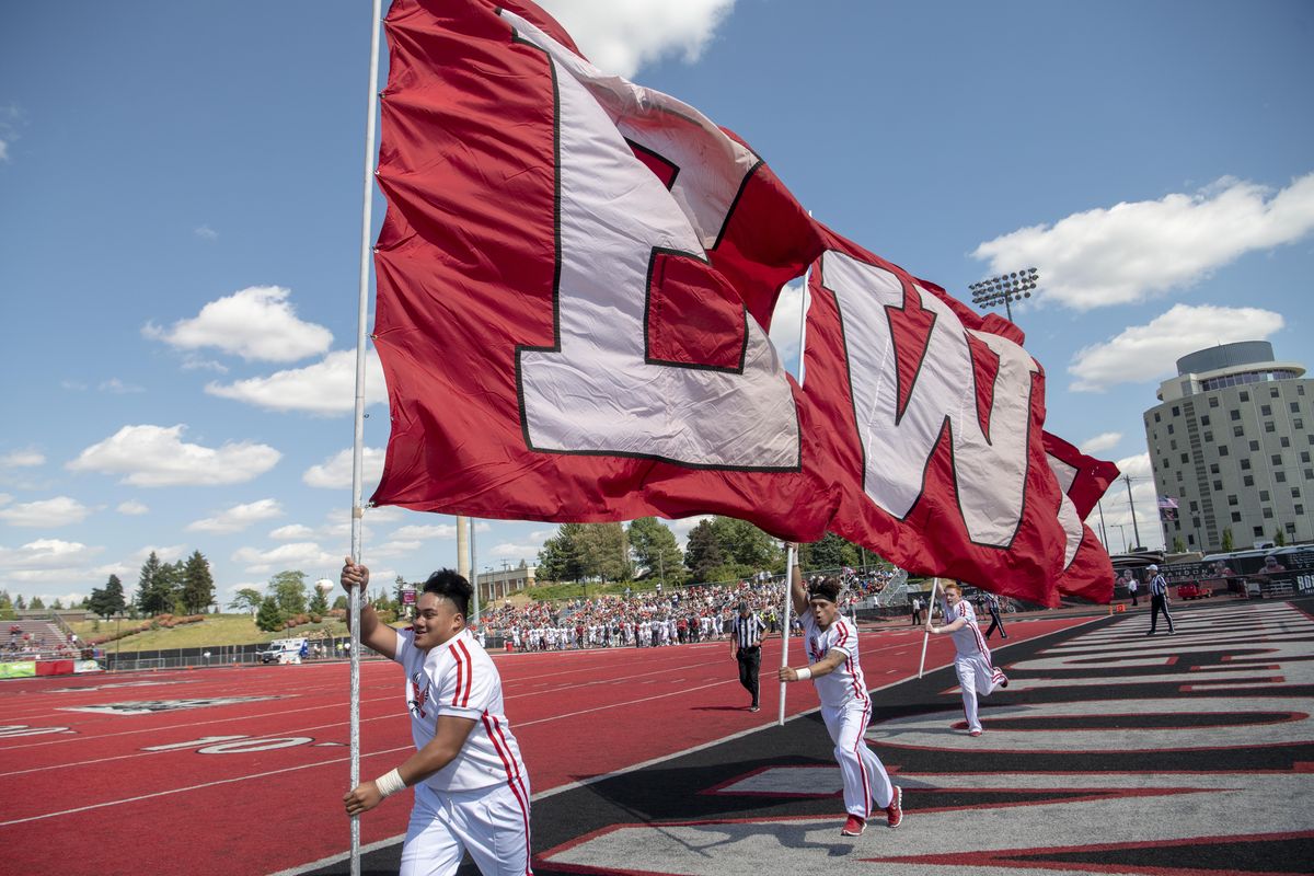 Cheerleaders run with EWU flags after one of many scores during the EWU/CWU game Saturday, Sept. 1, 2018 at Roos Field at Eastern Washington University in Cheney. (Jesse Tinsley / The Spokesman-Review)