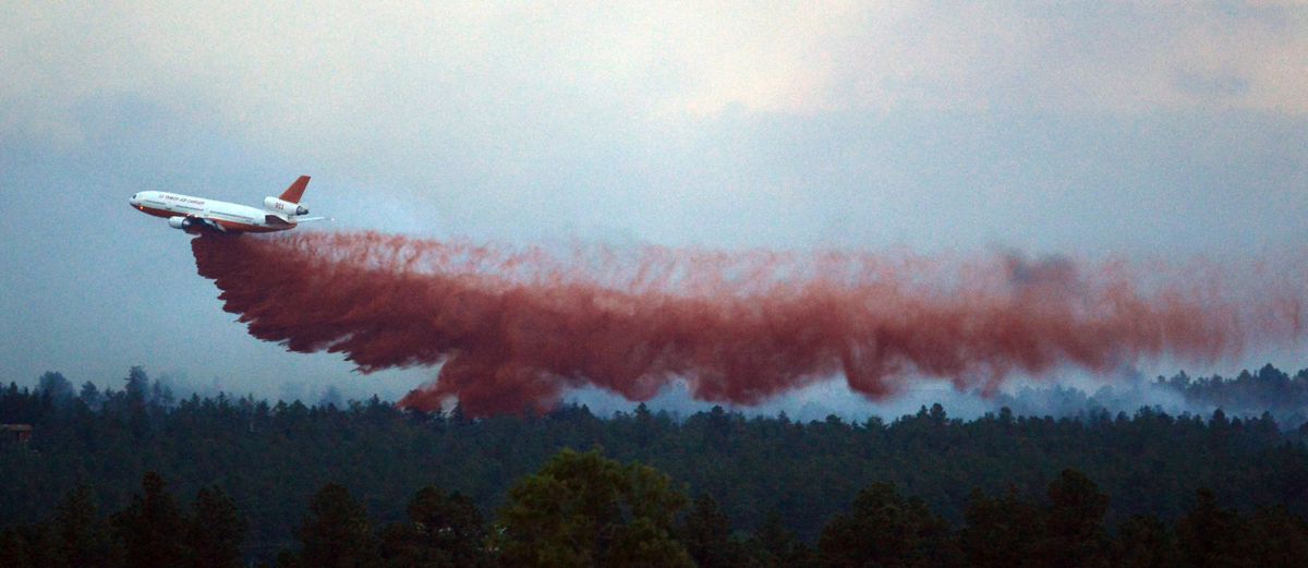 A DC-10 Air Tanker drops fire retardant near home in the evening as the Black Forest Fire continues to burn out of control for a second straight day near Colorado Springs on Wednesday, June 12, 2013. The fire has consumed 11,500 acres. It has destroyed 92 homes and damaged others. The erratic fire has forced the evacuation of thousands of people. (Bryan Oller / Fr81708 Ap)