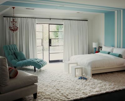 A bedroom designed by Betsy Burnham, with walls of pure white and frosty blue complemented by a fluffy snow-white flokati rug.