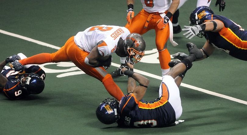 Spokane Shock #9 Sergio Gilliam graps a leg, #3 Nygel Rogers tears off the helmet and #91 Harrison Nikoloa swoops in to finish off Boise's #2 Ahmad Harris in the 1st quarter, May 10, 2008 in the Spokane Arena.  DAN PELLE The Spokesman-Review (Dan Pelle / The Spokesman-Review)