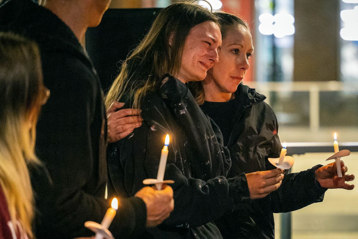 Robert Bradley’s fiancée, Sarah McLaughlin, center, is comforted by Jessie Allum during a candlelight vigil in Riverfront Park. Bradley was fatally shot at his home in Hillyard on Sept. 4, 2022, by Spokane police officers.  (COLIN MULVANY/THE SPOKESMAN-REVIEW)