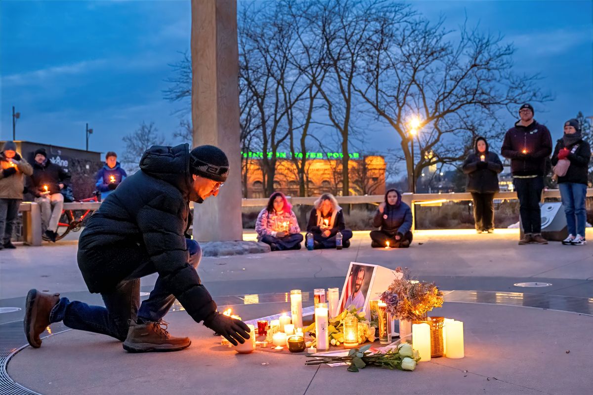 Mauricio Segovia places a candle during a memorial vigil for Alex Pretti who was shot and killed by a U.S. Border Patrol agent in Minneapolis last weekend. Over 100 people circled around a small memorial holding lit candles on Monday at Rotary Fountain in Riverfront Park. (COLIN MULVANY /THE SPOKESMAN-REVIEW)