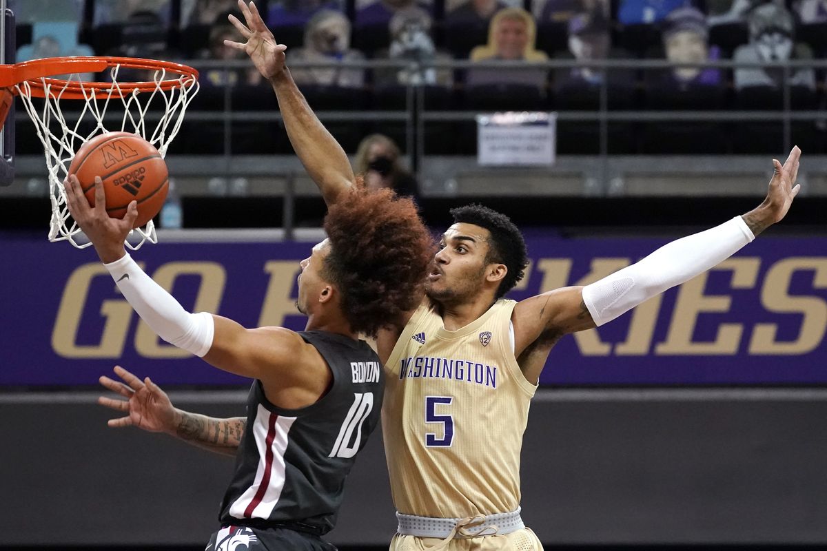 Washington’s Jamal Bey defends as Washington State’s Isaac Bonton scores two of his game-high 25 points Sunday in Seattle.  (Associated Press)