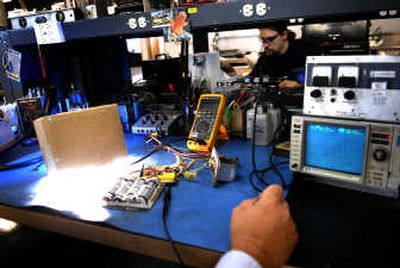 
Russ Ruchert works on a wingtip strobe as Dustin Magnus repairs a flush pump motor in the background in Friday. Both men are electronics technicians and work for Absolute Aviations, a business that repairs aviation components. 
 (Jed Conklin / The Spokesman-Review)