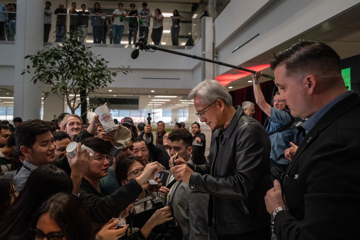 Jensen Huang, president and CEO of Nvidia, signs autographs for Taiwan Semiconductor Manufacturing Company workers after speaking at the company’s plant Oct. 17 in Phoenix. The transformation of Phoenix into a semiconductor hub by Taiwan’s TSMC illustrates the difficulties of large-scale projects in the United States.  (LOREN ELLIOTT)
