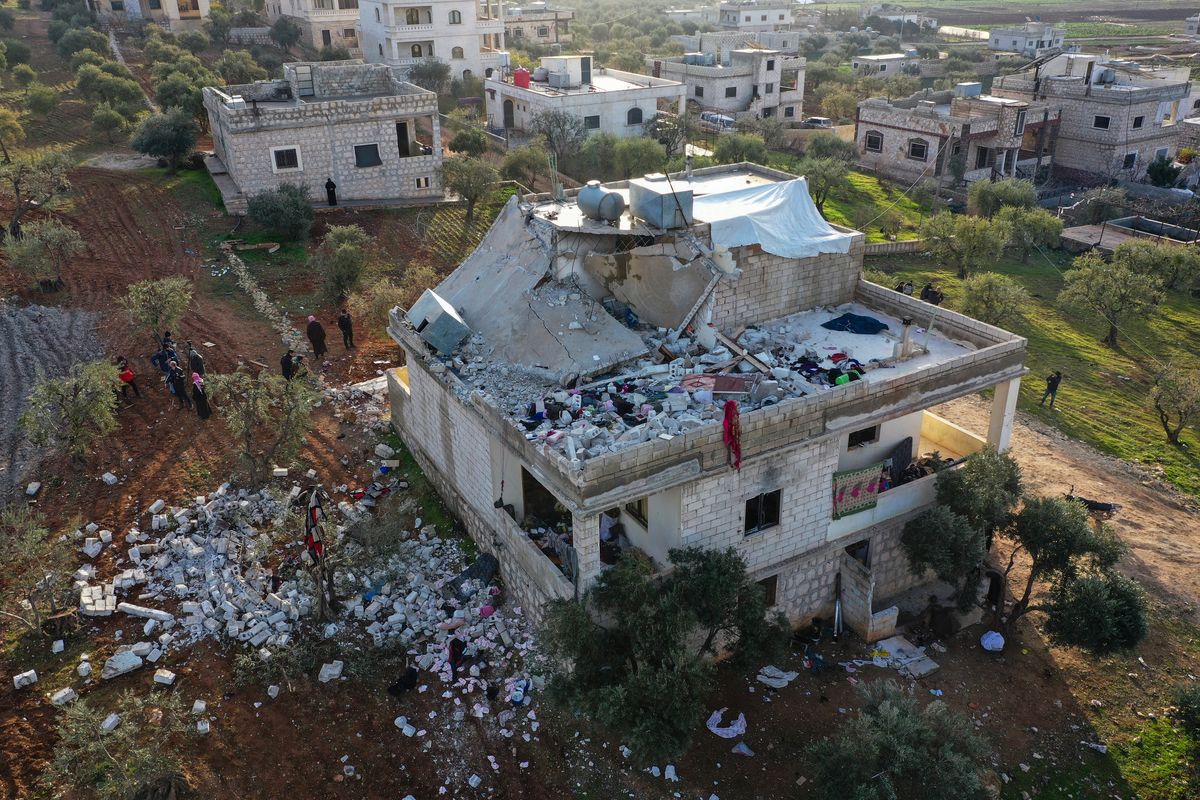 People inspect a destroyed house following an operation by the U.S. military in the Syrian village of Atmeh, in Idlib province, Syria, Thursday, Feb. 3, 2022. U.S. special operations forces conducted a large-scale counterterrorism raid in northwestern Syria overnight Thursday, in what the Pentagon said was a "successful mission." Residents and activists reported multiple deaths including civilians from the attack. (Ghaith Alsayed)