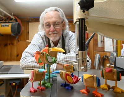 Lawrence Killingsworth is photographed with some of the wooden birds, including Jaz, far left, and Larry Bird, with long green legs, next to her.  (Jesse Tinsley/THE SPOKESMAN-REVI)