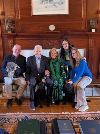 Former President Joe Biden and former first lady Jill Biden pose with their newly adopted black lab mix dogs.  (Reuters )