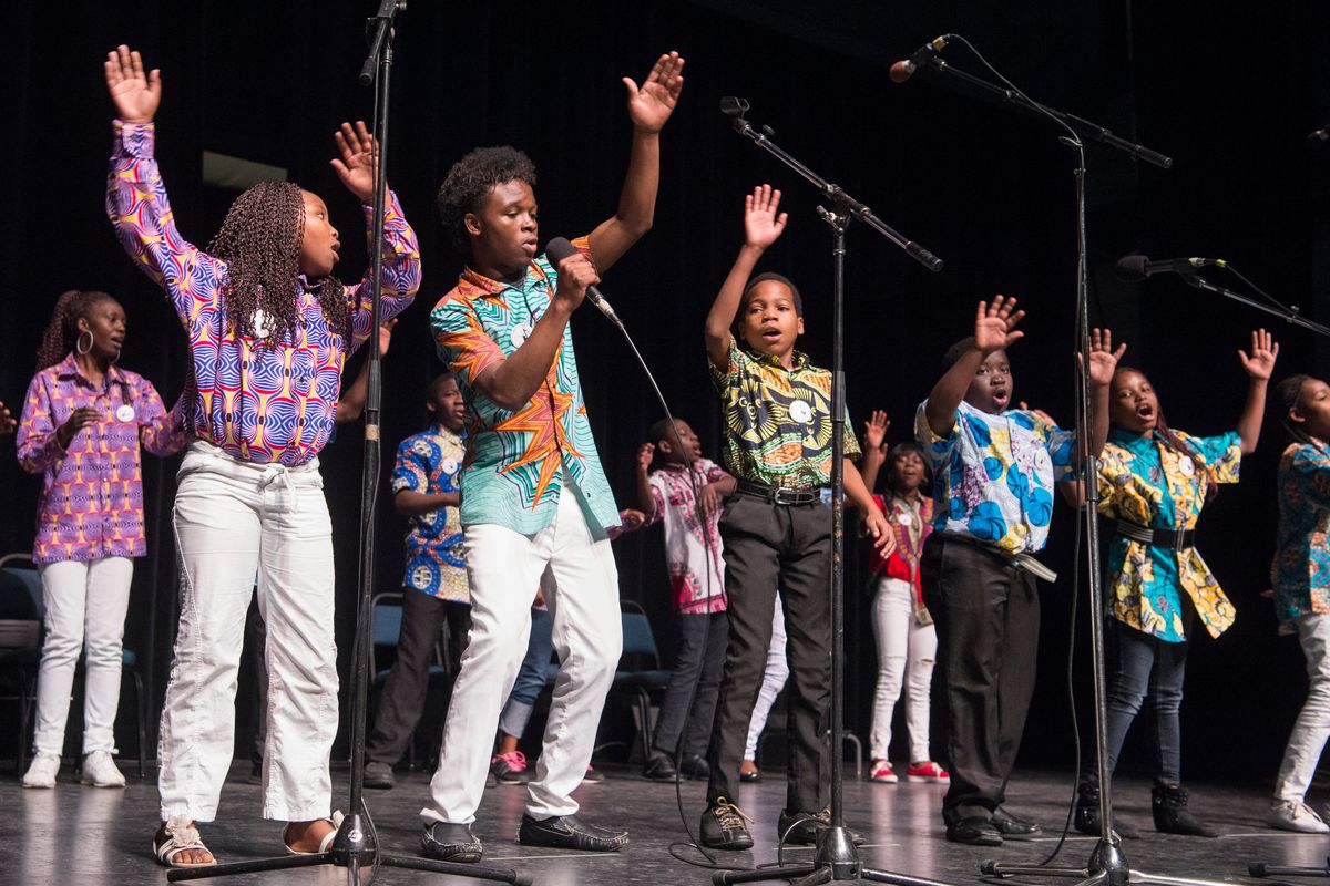 Solomon Katumbi, with microphone, sings the solo, leading the Neema Youth Choir in their first song at the 2017 Fall Folk Festival at Spokane Community College.  (JESSE TINSLEY)