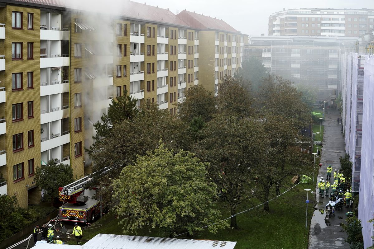 FILE - In this Tuesday Sept. 28, 2021 file photo, smoke billows from an apartment building after an explosion in Annedal, central Gothenburg, Sweden. Swedish police said Thursday Sept. 30, 2021, they are seeking a man in connection with an explosion and fire at a large apartment building this week that injured 16 people, four of them seriously.  (Bjorn Larsson Rosvall)
