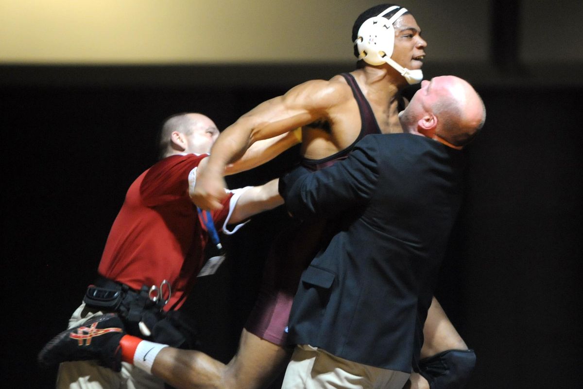 In this 2011 photo, North Idaho College’s Jamelle Jones jumps into the arms of his coach, Pat Whitcomb. On Wednesday, Whitcomb said he was fired Jan. 7 from NIC in part so that the school can drop wrestling and add baseball. (Jesse Tinsley / The Spokesman-Review)