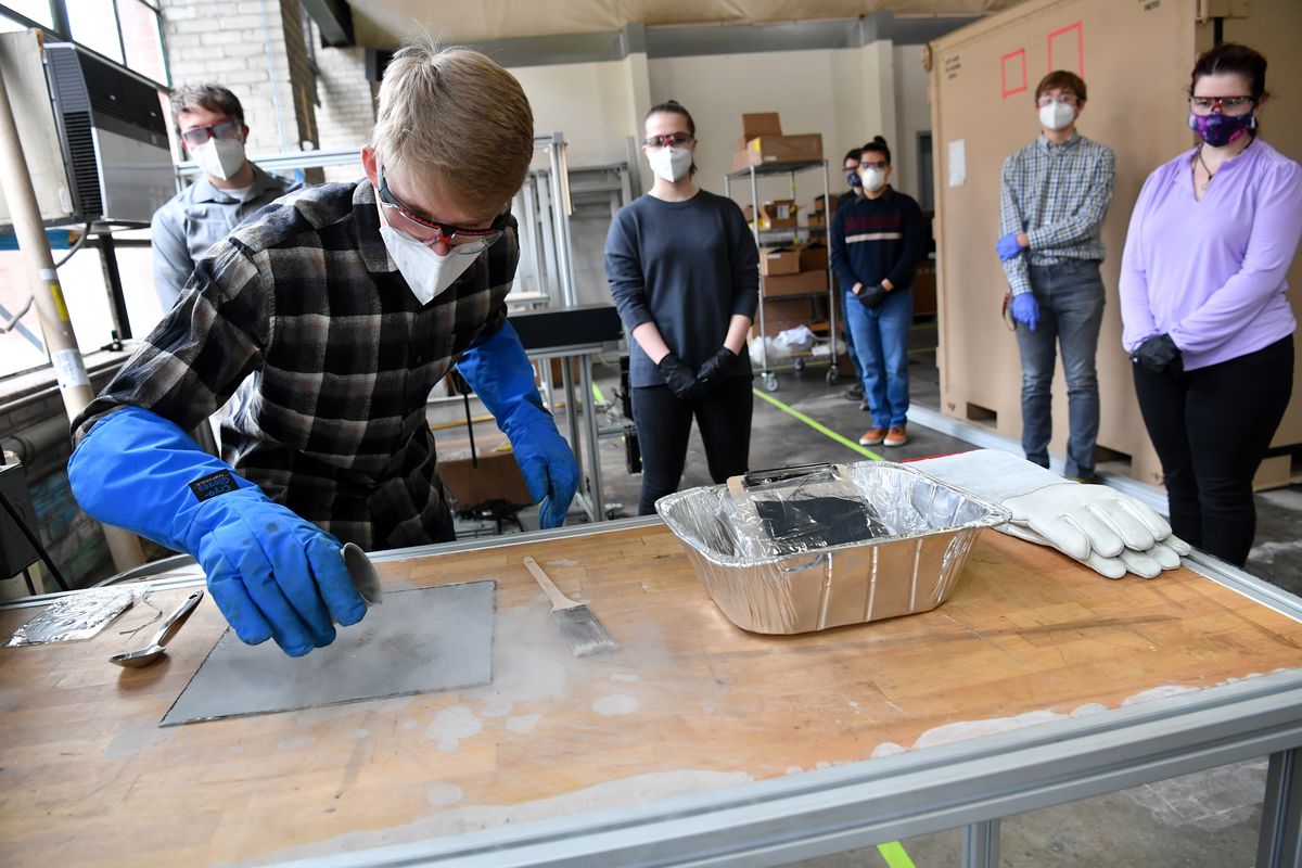 Nathaniel Swets demonstrates the use of liquid nitrogen as a transport mechanism to remove and clean Mt. St. Helens ash – simulating moon dust – off of various materials on Thursday at Washington State University in Pullman.  (Tyler Tjomsland/THE SPOKESMAN-REVIEW)