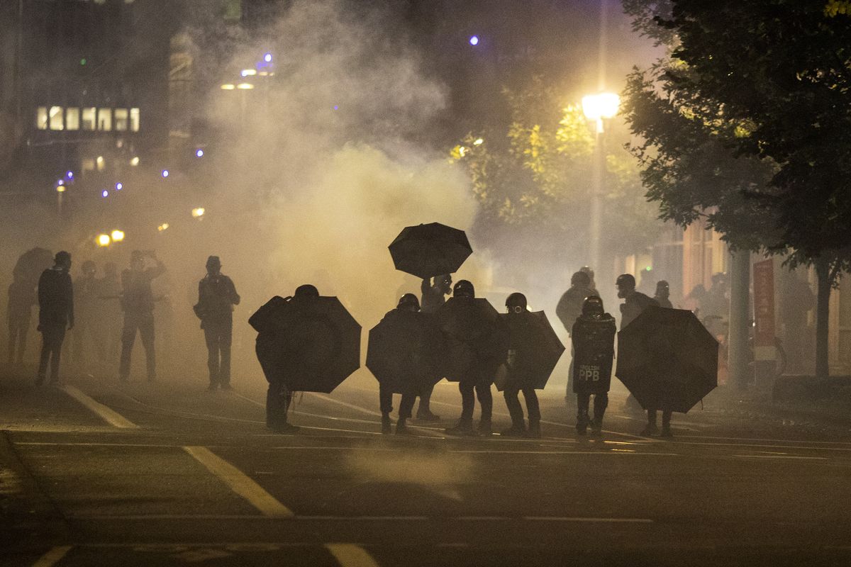 FILE - In this Sept. 18, 2020, file photo, tear gas fills the air during protests in Portland, Ore. An Oregon lawmaker is seeking to ban the use of tear gas and other agents against crowds of people in one of the most sweeping police measures in the country regarding crowd control devices.  (Paula Bronstein)