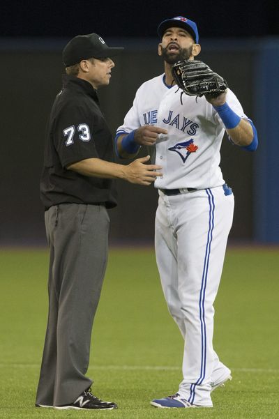 Toronto’s Jose Bautista, right, is restrained by second-base umpire Tripp Gibson on Tuesday. (Associated Press)