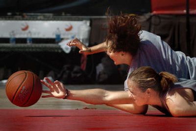 
Team Idaho's Megan Kane, bottom, and GU Blackouts' Anne Bailey reach for a loose ball in the women's final game at Riverfront Park on Sunday.
 (Joe Barrentine / The Spokesman-Review)