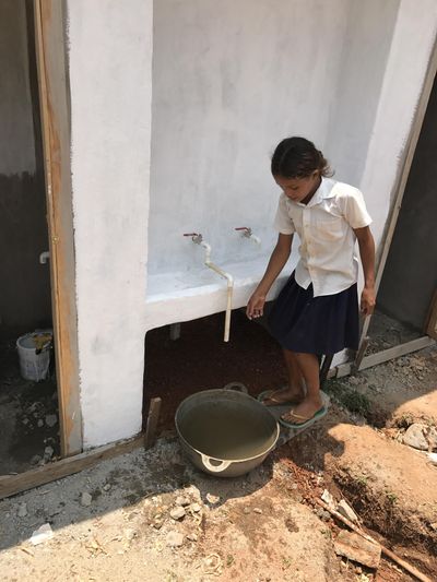 A schoolgirl gets water at hand-washing station built into a new double latrine  in Honduras. Chris Choate, who helped build the facility, has planned another trip to southern Honduras in April to work on a clean water project. (Chris Choate / Courtesy photo)