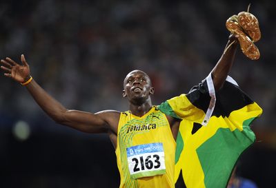 Jamaica’s Usain Bolt celebrates with the Jamaican flag.  (Associated Press / The Spokesman-Review)