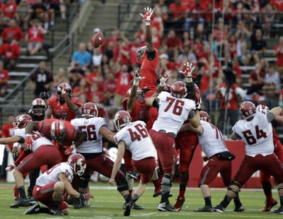 Washington State kicker Erik Powell launches a first-half field goal against the Rutgers defense on the way to a 3-for-3 day. (Associated Press)