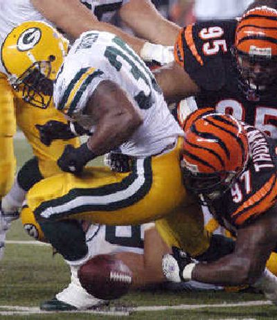 
Packers' running back Ahman Green (30) fumbles the ball as he is tackled.
 (Associated Press / The Spokesman-Review)