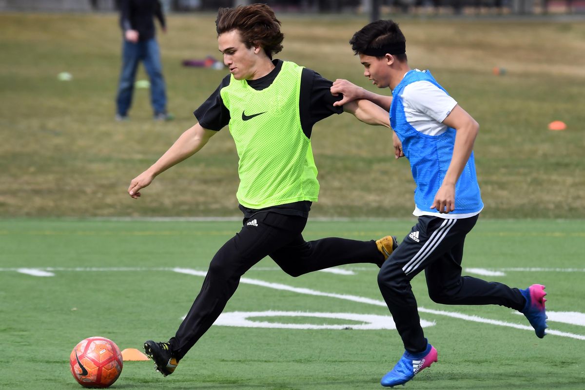 North Central High School midfielder Aidan Chaparro, left, advances the ball against teammate Reese Washburn during practice, Monday, April 10, 2018, at the Merkel Complex in Spokane, Wash. (Dan Pelle / The Spokesman-Review)