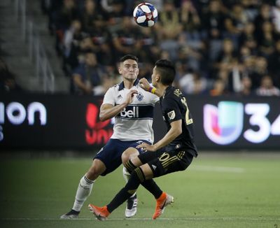 Vancouver Whitecaps defender Jake Nerwinski, left, vies for the ball with Los Angeles FC midfielder Eduard Atuesta during the second half Saturday’s game in Los Angeles. (Alex Gallardo / Associated Press)