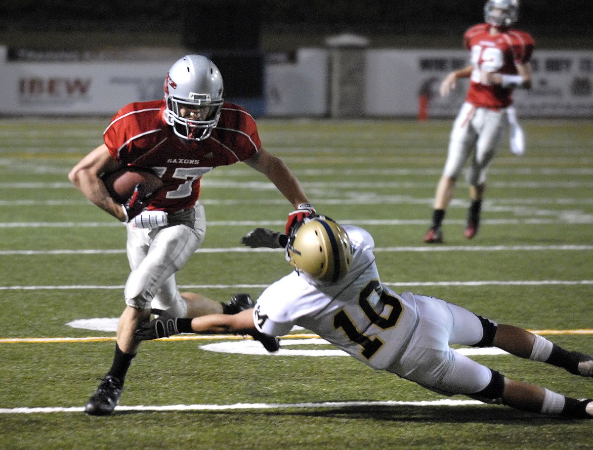 Ferris receiver Aaron Roberts disposes of Mead’s Brendon Myers during last Friday night’s game at Albi Stadium.  (Dan Pelle / The Spokesman-Review)