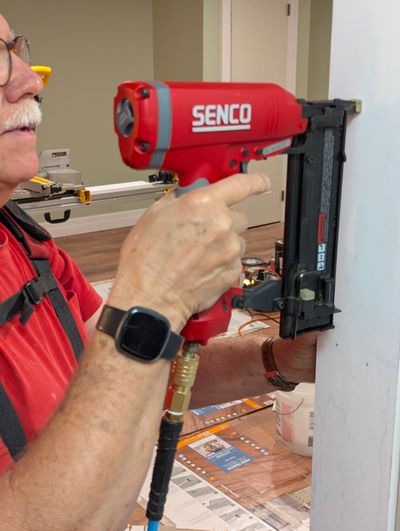 Tim Carter using one of his favorite tools of all time: a pneumatic gun that fires thin finish nails and countersinks them too!  (Tribune Content Agency)
