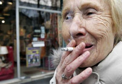 
A woman smokes outside a shop  in Paris on Thursday, days before a smoking ban is set to extend to most public places in France. Associated Press
 (Associated Press / The Spokesman-Review)
